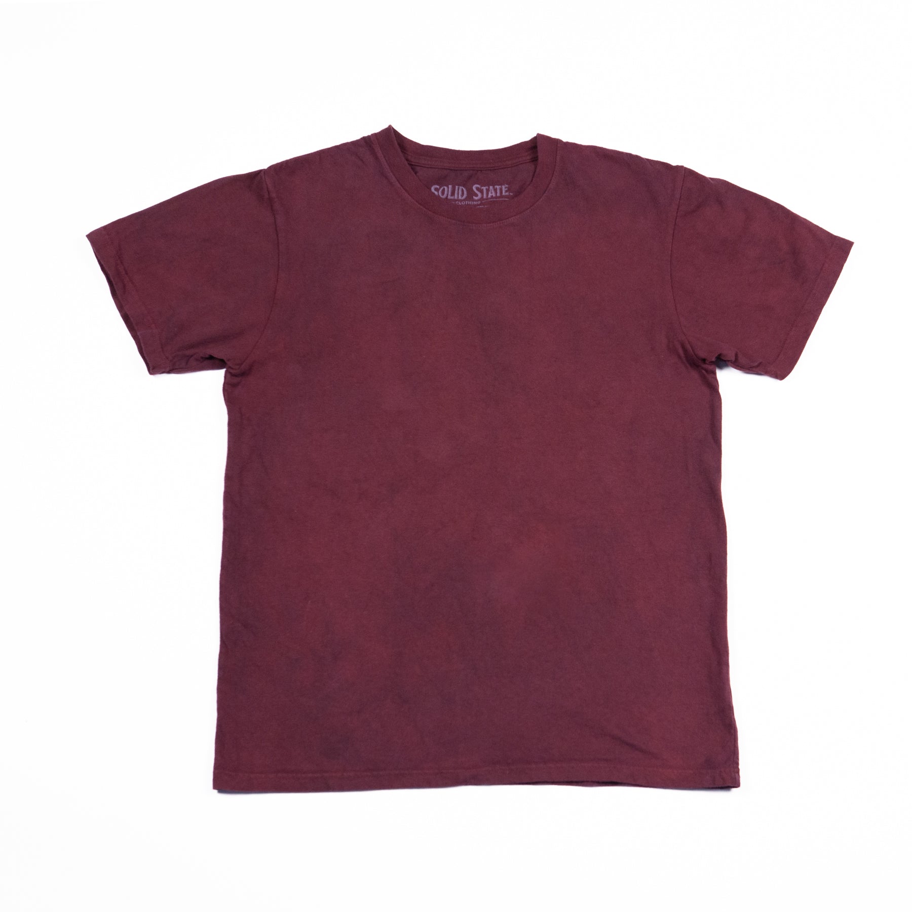 A crewneck t-shirt made in the USA and dyed with madder root standing laying flat on a white background