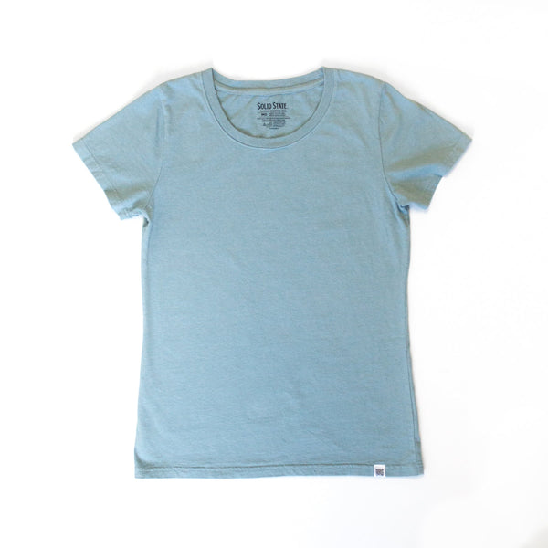 An American-made Solid State Clothing North Carolina Cotton T-Shirt lies against a white background. The color of the shirt is Sea Foam, which is a lighter, muted shade of blue