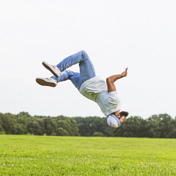 Man doing a back flip while wearing a white Solid State Clothing Homesteader Fit M t-shirt