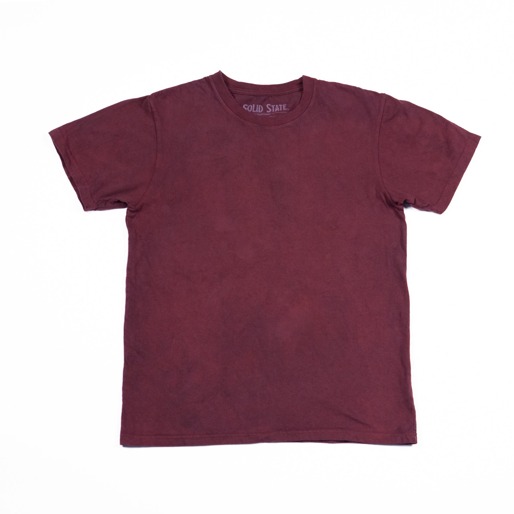 A crewneck t-shirt made in the USA and dyed with madder root standing laying flat on a white background