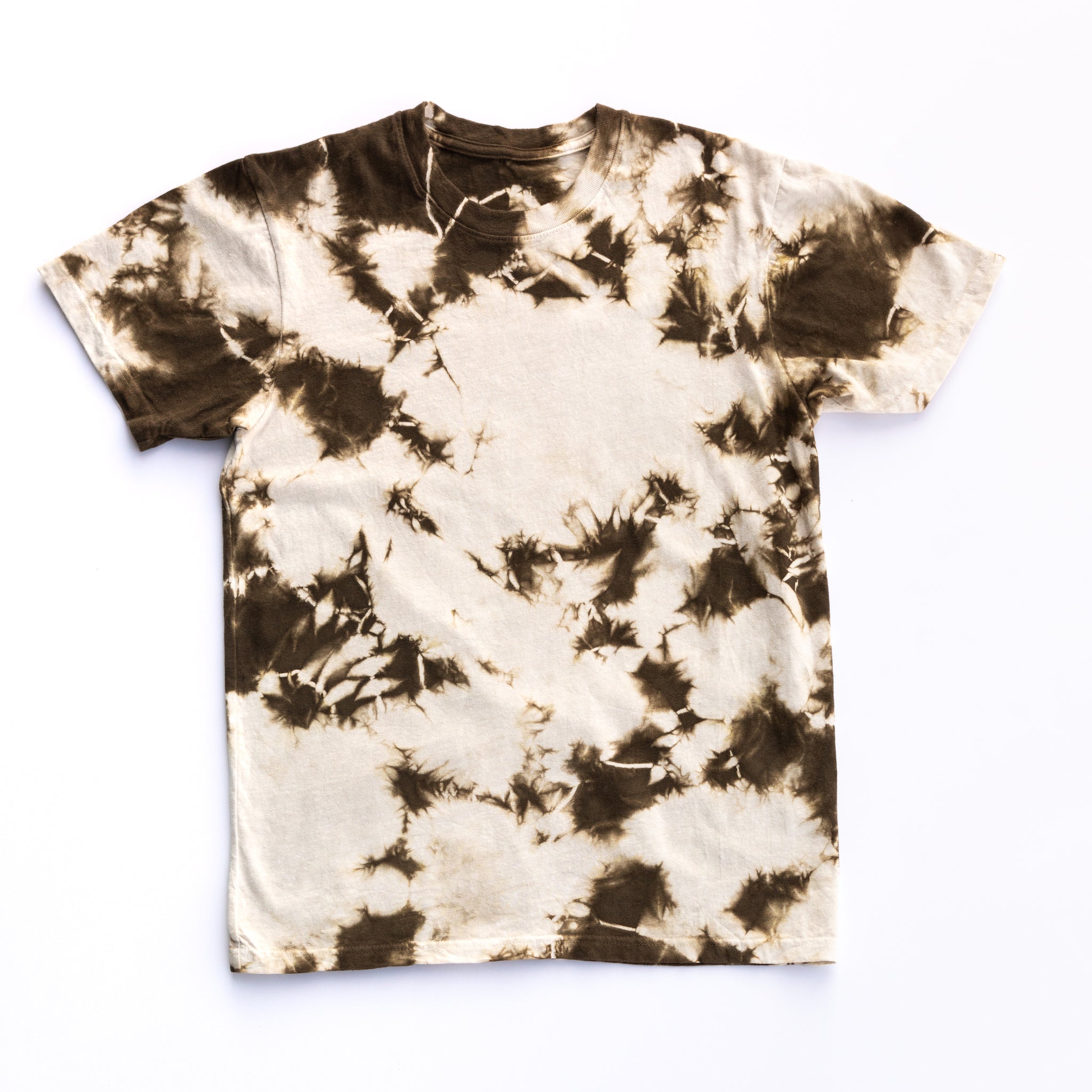 A Solid State Clothing Natural Tie Dye t-shirt lies against a plain background. Because each shirt is hand dyed in the USA, the pattern varies in all photos of shirts. The shirt pictured here has more white than green in its pattern