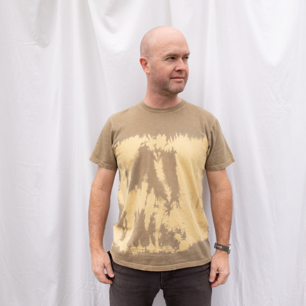 Man wearing an American-made Solid State Clothing t-shirt in natural tie dye color Riverbed.